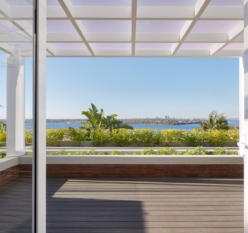 Patio view overlooking tranquil blue lake and greenery.