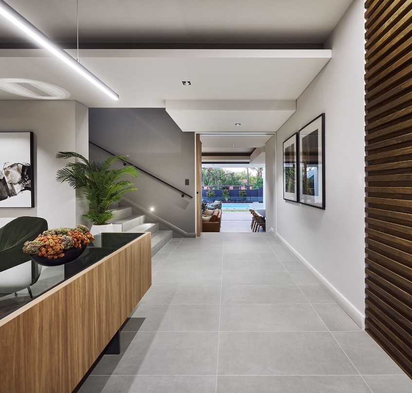 Modern home interior with staircase and pool view.