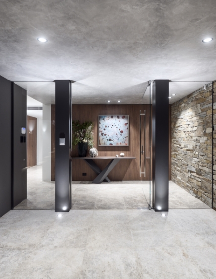 Modern lobby with artistic wall clock and stone accent.