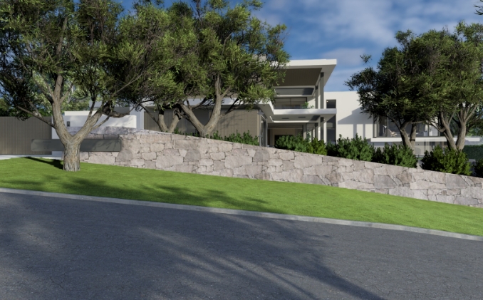 Modern house with trees and stone wall.